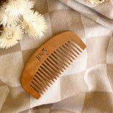 Wooden comb on a textured fabric background with flowers
